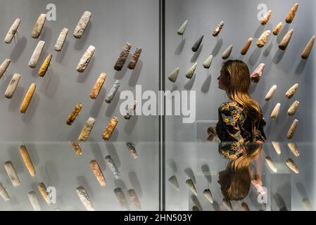 Londra, Regno Unito. 14 febbraio 2022. Un membro dello staff si pone con assi in pietra lucida. Anteprima di “il mondo di Stonehenge” al British Museum”, la prima grande mostra del Regno Unito a Stonehenge che presenta oltre 430 oggetti in mostra da Gran Bretagna, Irlanda ed Europa. I lavori sono esposti dal 17 febbraio al 17 luglio 2022. Credit: Stephen Chung / Alamy Live News Foto Stock