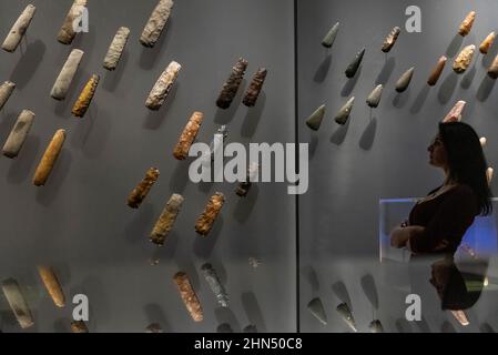 Londra, Regno Unito. 14 febbraio 2022. Un membro dello staff si pone con assi in pietra lucida. Anteprima di “il mondo di Stonehenge” al British Museum”, la prima grande mostra del Regno Unito a Stonehenge che presenta oltre 430 oggetti in mostra da Gran Bretagna, Irlanda ed Europa. I lavori sono esposti dal 17 febbraio al 17 luglio 2022. Credit: Stephen Chung / Alamy Live News Foto Stock