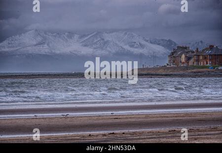 Una vista di un giorno di inverni delle cime innevate sulle montagne Isola di Arran visto dalla spiaggia di Troon Foto Stock