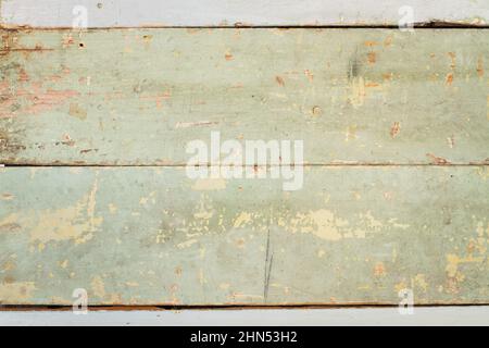 Una texture di legno verde con urti e crepe in una vista ravvicinata Foto Stock