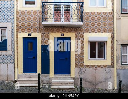 Lisbona, Portogallo - 12 28 2018: Facciata tipica portoghese con piastrelle e due piccole porte blu Foto Stock