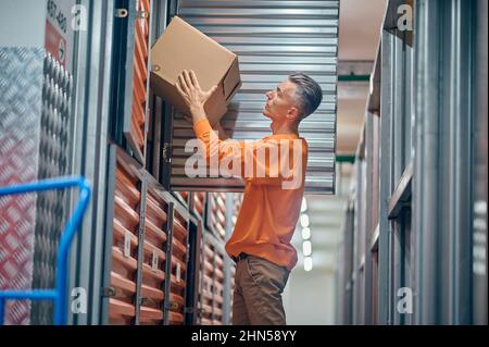 Addetti al magazzino concentrati che scaricano merci all'interno Foto Stock