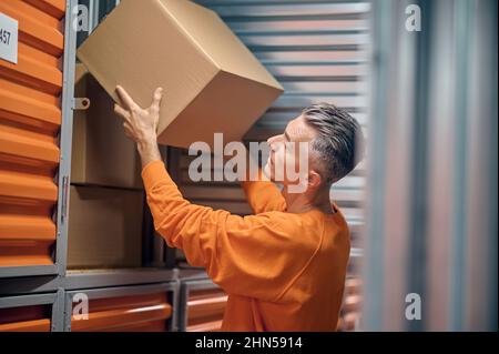 Commissionatore che sceglie gli articoli ordinati per la consegna Foto Stock