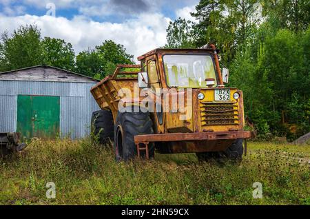 Vecchio e arrugginito camion di scarico Kockum abbandonato di fronte a un capannone di stagno in ambiente rurale e rustico, vicino Mellerud, Dalsland, Svezia. Foto Stock