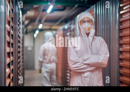 Due dipendenti del magazzino indossano indumenti protettivi nell'area di stoccaggio Foto Stock