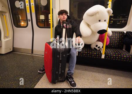 Una persona con un regalo di San Valentino sulla Circle Line, nella zona est di Londra. Data foto: Lunedì 14 febbraio 2022. Foto Stock