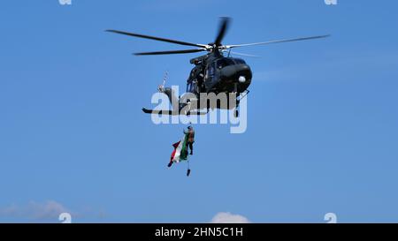 Thiene Italia, 16 OTTOBRE 2021 bandiera italiana che vola appesa al verricello di un elicottero militare in volo. AgustaWestland AW139 Leonardo HH139 di Foto Stock