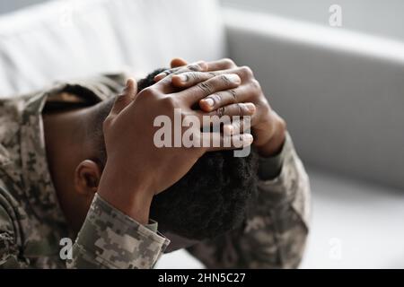 Uomo nero militare irriconoscibile che ricopre la testa di palme Foto Stock