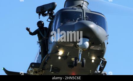 Thiene Italia, 16 OTTOBRE 2021 Rescuer si affaccia dalla porta laterale di un elicottero di salvataggio e di ricerca militare volante. Vista ravvicinata. AgustaWestland, AW Foto Stock