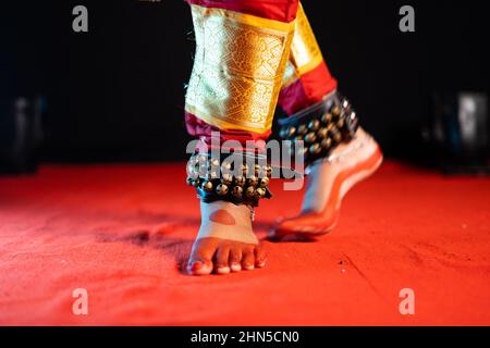 Primo piano di bharatanatyam indiano ballerino piedi con ghungroo kathak o danza musicale caviglia sul palco - concetto di cultura indiana, danza classica Foto Stock