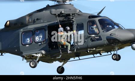 Thiene Italia, 16 OTTOBRE 2021 Rescuer scende con il verricello dal portello laterale di un elicottero militare. Salvataggio in condizioni estreme. Agusta Wes Foto Stock