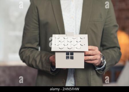 primo piano della casa modello nella mano del vero agente estete dell'architetto maschile. Foto di alta qualità Foto Stock