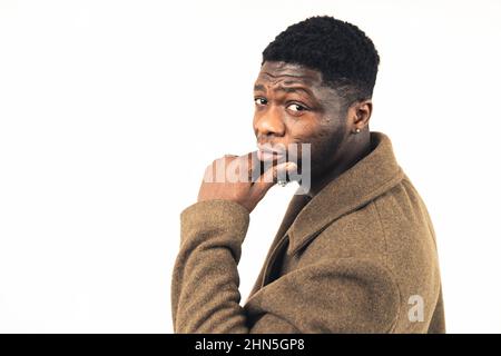 ragazzo nero sospetto con la mano sul mento sfondo bianco - primo piano-up colpo. Foto di alta qualità Foto Stock