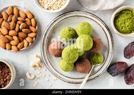 Palle di tè verde o tartufi di proteine vegane su un piatto. Dolci sani fatti in casa Foto Stock