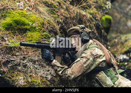 Prendendo la copertura mentre spara attivamente sul soldato della guardia femminile di terra. Foto di alta qualità Foto Stock