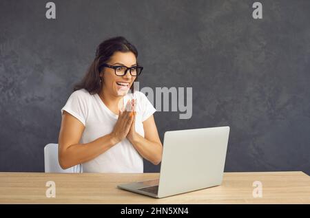 Donna eccitata trionfa con buone notizie sul computer Foto Stock