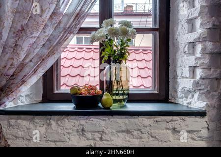 vaso con fiori sul davanzale in vecchio stile vintage con frutta o candele Foto Stock