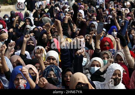 I membri di Islami Jamiat Tuba stanno organizzando un rally di protesta contro il recente divieto di hijab in alcuni college dello stato di Karnataka in India, presso l'Università di Karachi a Karachi lunedì 14 febbraio 2022. Foto Stock