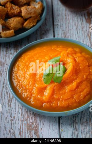 Ciotola di zuppa di zucca con crostini di formaggio e prezzemolo Foto Stock