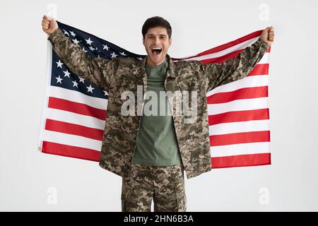 Ragazzo militare allegro con bandiera degli Stati Uniti su bianco Foto Stock