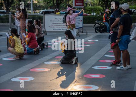 La gente è vista pregare al santuario dei Trimuriti a Bangkok. L'evento "Pregate and swipe right" organizzato da online dating app Tinder, con i contrassegni del logo Social Distancing Tinder sul terreno di preghiera, uno stand fotografico dove le persone possono scattare foto del profilo per i loro nuovi account, e set di offerte gratuite, presso il santuario dei Trimuriti il giorno di San Valentino a Bangkok, in Thailandia. Il Trimuriti uno degli dèi indù è conosciuto per essere il dio dell'amore. La gente viene ad adorare al santuario dei Trimurti con offerte di rose rosse nella speranza che incontrino il suo compagno di anima. Foto Stock