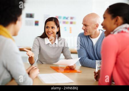 Theres non migliore lavoro che lavoro di squadra. Girato di un gruppo di uomini d'affari casualmente vestiti in ufficio. Foto Stock