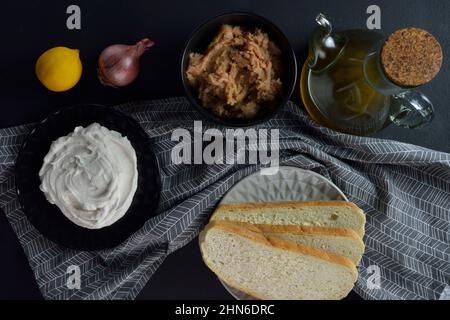 Ingredienti per fare taramosalata e taramosalata bianca pronta immergere in piastra nera Foto Stock