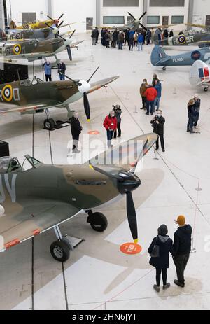 Imperial War Museum Duxford - visitatori che guardano la mostra di aerei da spitfire della Guerra Mondiale 2 in un hangar, Duxford IWM, Duxford UK Foto Stock