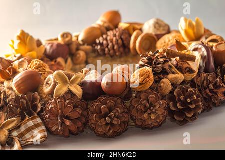 Motivo di Natale, ghirlanda intrecciata da coni di pino e ghiande isolate su sfondo bianco. Foto Stock