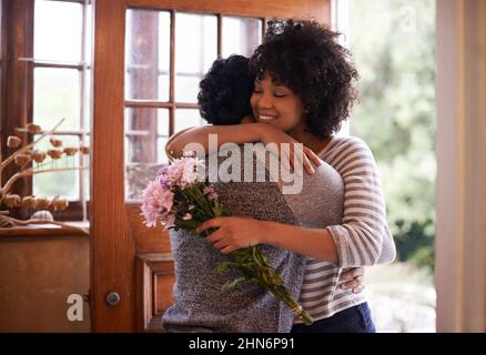 Grazie per i fiori. Scatto corto di una giovane coppia affettuosa che abbraccia la porta. Foto Stock