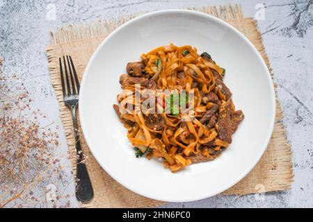 Char KWAY Teow / Riccio fritto con manzo su un piatto bianco Foto Stock