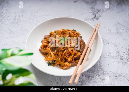 Char KWAY Teow / Riccio fritto con manzo su un piatto bianco Foto Stock