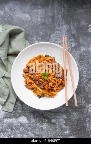 Char KWAY Teow / Riccio fritto con manzo su un piatto bianco Foto Stock