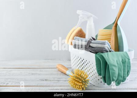 Set di materiali di consumo per la pulizia di colore blu in un cestello di plastica su sfondo blu Foto Stock