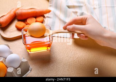 Donna che muore uova di Pasqua su tavola colorata, primo piano Foto Stock