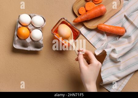 Donna che muore uova di Pasqua su sfondo colorato Foto Stock