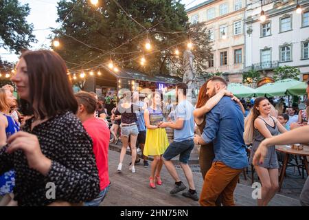 Lviv, Ucraina - 15 luglio 2018: Ballerini di salsa in un caffè all'aperto vicino alla fontana di Diana nella piazza del mercato di Lviv Foto Stock