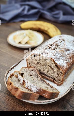 Pane di banana appena sfornato sul piatto con fette di banana primo piano Foto Stock