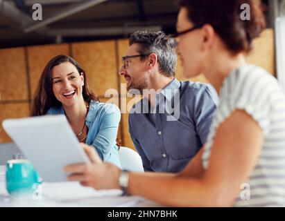 Fare domani successo oggi. Foto di un gruppo di colleghi che hanno una riunione in un ufficio open plan. Foto Stock