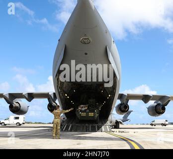 Un aviatore serve come guida di terra per scaricare un veicolo da combattimento i Corps Stryker da un Airlift Wing C-17 Globemaster III 62nd alla base dell'aeronautica di Andersen, Guam, 4 febbraio 2022. I membri del primo corpo americano si sono schierati dalla Joint base Lewis-McChord a Guam per condurre un esercizio di formazione che accresce la prontezza, mette in mostra l’interoperabilità congiunta ed esercita il comando di missione distribuito nel Pacifico. (STATI UNITI Esercito foto di SPC. Jailene Bautista, 5th distaccamento Mobile Public Affairs) Foto Stock