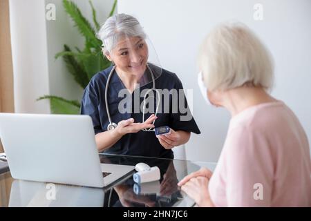 Paziente anziano con l'infermiere su appuntamento Foto Stock