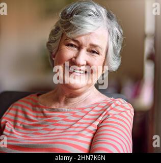 Contenuto nei suoi anni d'oro. Shot di una donna anziana che si rilassa a casa. Foto Stock