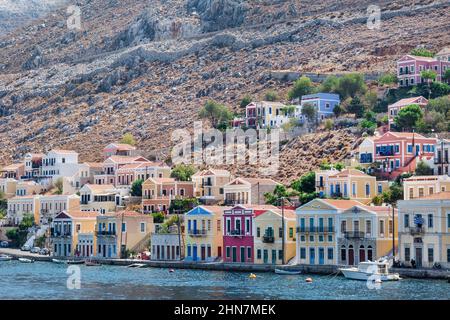 Seascape con vista panoramica delle tradizionali case colorate e la porta chiamato Yalos con le barche a vela in Symi isola Dodecaneso, Grecia. Foto Stock