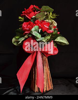 Rose artificiali in vaso di canna Foto Stock