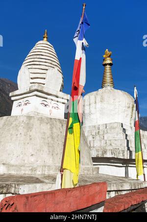 Stupa con bandiere di preghiera e ruote sulla strada da Lukla a Namche bazar nel villaggio di chaurikharka vicino cheplung villaggio - nepal Foto Stock