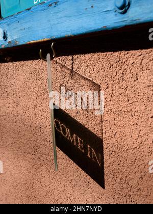 Un cartello aperto in plastica proietta un'ombra sul muro di una galleria d'arte a Santa Fe, New Mexico. Foto Stock