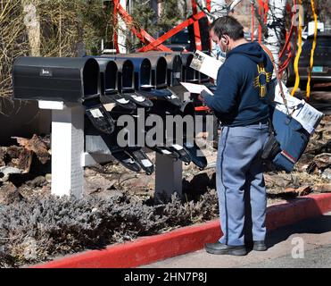 Un mailman americano o un corriere di lettere consegna la posta ad una fila di caselle postali a Santa Fe, New Mexico. Foto Stock