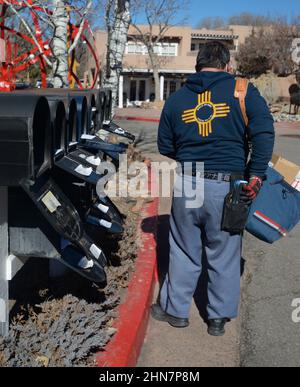 Un mailman americano o un corriere di lettere consegna la posta ad una fila di caselle postali a Santa Fe, New Mexico. Foto Stock