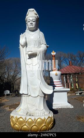 Una statua di Quan am, la bodhisattva della compassione, di fronte ad un negozio di articoli da regalo tibetani a Santa Fe, New Mexico. Foto Stock