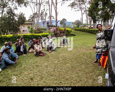 Gli anziani del Papuan seduti sull'erba durante un incontro di comunità, ascoltando attentamente l'oratore Foto Stock